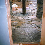 An old millstone formerly used to ground wheat was incorporated into this handmade natural native fieldstone pathway. The decorative grating around the tree was put in place to provide a surface on which to walk which prevented having to cut the tree down to accommodate the pathway. The grating sections remove to accommodate tree growth.